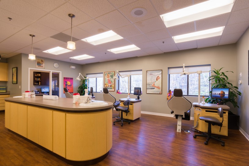 A dentist 's office with several dental chairs in the center.