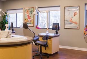 A dentist 's office with a desk and chair.