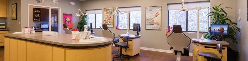 A dentist 's office with a desk and chair.